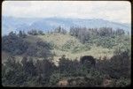 Western Highlands: mountains, trail descending a hillside, a few houses visible on ridge