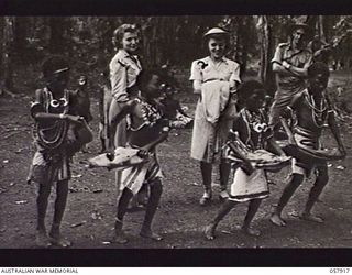 DOBODURA, NEW GUINEA. 1943-10-10. LIEUTENANT (LT) DOROTHY NAU (WEST VIRGINIA) (LEFT), AND LT RITA SPIERS (OHIO), WATCHING NATIVE CHILDREN DOING A SPECIAL DANCE