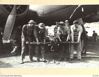 1942-12-07. NEW GUINEA. A 105MM M-3A1 HOWITZER COMPLETE WITH SPARES, TRACTOR AND AMMUNITION IS UNLOADED SOMEWHERE IN THE BATTLE AREA. THE GUN CREW ALSO CAME WITH THE GUN. PICTURE SHOWS A PORTION OF ..