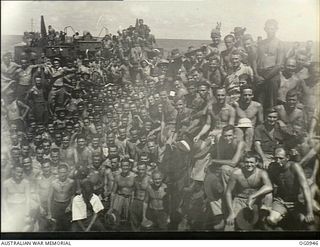 AT SEA NEAR AITAPE, NORTH EAST NEW GUINEA. 1944-04-21. PREPARED FOR ACTION, SUN-BROWNED BARE-CHESTED PERSONNEL OF MOBILE WORKS UNITS, DESIGN AND SURVEY UNITS, AND SIGNALS UNITS, RAAF, GATHER ON THE ..