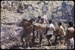 Land clearing: men clear trees and bushes from rocky land, preparing for construction