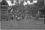 Mortuary ceremony: women gathered for exchange of banana leaf bundles and other wealth items, near chief's house and yam houses