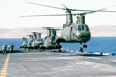 A Marine CH-46 Sea Knight helicopter lifts off from the deck of the amphibious assault ship USS SAIPAN (LHA-2). Four other Sea Knights are also visible