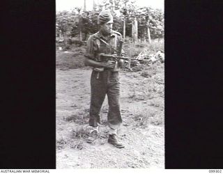 RABAUL, NEW BRITAIN, 1945-12-06. AN OWEN GUNNER DEMONSTRATING THE OWEN GUN DURING A DEMONSTRATION OF VARIOUS INFANTRY WEAPONS