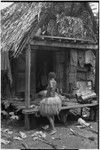 Mortuary ceremony: display of uprooted taro plants and mats, woman in long fiber skirt