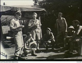 TOROKINA, BOUGAINVILLE ISLAND, SOLOMON ISLANDS. 1945-01-28. 19477 CORPORAL K. BATHURST, MELBOURNE, VIC (LEFT), EXCHANGES EXPERIENCES WITH ROYAL NEW ZEALAND AIR FORCE GROUND STAFF OVER THE ..