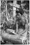 Man beating on a log as if he were playing an 'o'o slitgong