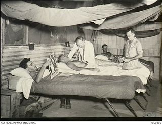 NEW GUINEA. C. 1943-09. SQUADRON LEADER D. R. MUNRO OF GLOUCESTER, NSW, MEDICAL OFFICER, DURING HIS ROUNDS OF THE WARDS, ACCOMPANIED BY LEADING AIRCRAFTMAN P. H. LITTLETON OF ESK, QLD, ORDERLY, ..