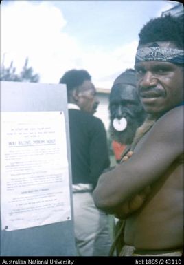 Man standing next to election signage