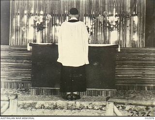 MADANG, NEW GUINEA. 1944-12-19. CHAPLAIN RUSSELL CLARK, THE COMMAND CHURCH OF ENGLAND CHAPLAIN, CELEBRATING HOLY COMMUNION AT THE FIRST DEDICATION SERVICE OF THE RAAF MEMORIAL CHAPEL AT THE FORWARD ..