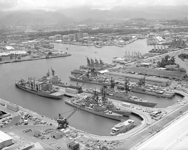 An aerial view of the Naval Shipyard with various ships moored to piers during Exercise RIMPAC '86