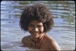 Young woman bathing, wearing shell necklaces