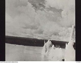 SORONG, NEW GUINEA. 1944-04. TWO NEAR MISSES AND A DIRECT HIT FROM A STRING OF BOMBS DURING AN ATTACK ON JAPANESE SHIPPING BY B25 BOMBER AIRCRAFT OF FIFTH AIR FORCE, UNITED STATES ARMY AIR FORCE. ..