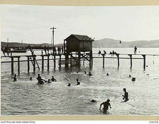 PORT MORESBY, PAPUA. 1942-08. A MORE CONVENTIONAL WAY OF KEEPING COOL. AUSTRALIAN SOLDIERS ENJOY THEIR SWIM IN THE OLD PUBLIC BATHS AT PORT MORESBY