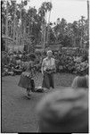 Mortuary ceremony, Omarakana: anthropologist Annette Weiner at exchange ritual, another woman puts betel nut clusters on exchange pile