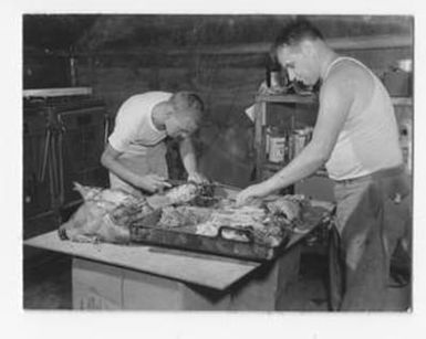 [Two Men Preparing Meat]