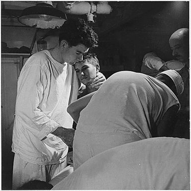 Pvt. J.B. Slagle, USA, receives his daily dressing of wounds on board USS Solace (AH-5) enroute from Okinawa to Guam.