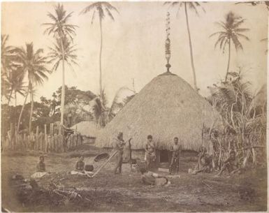 Kanak men and women in front of a native dwelling known as a grande case, New Caledonia, 1874 / Allan Hughan