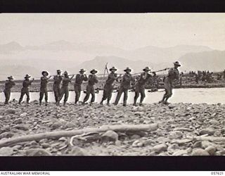 UMI RIVER, NEW GUINEA. 1943-09-29. TROOPS OF THE 2/6TH AUSTRALIAN FIELD COMPANY, ROYAL AUSTRALIAN ENGINEERS, HAULING RUBBER BOATS ACROSS THE RIVER. LEFT TO RIGHT: NX91317 SAPPER (SPR) C. SMITH; ..