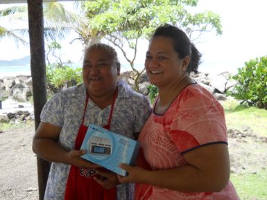 Pago Pago, American Samoa, April 25, 2012 -- American Samoa Office of Homeland Security staff presenting emergency warning radio to a local shop owner