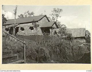 1943-06-25. NEW GUINEA. TWO NEW CHURCHES. IN THE FOREGROUND IS ST. PATRICK'S ROMAN CATHOLIC CHURCH, AND IN THE BACKGROUND THE ANGLICAN CHURCH OF THE RESURRECTION. (NEGATIVE BY N. BROWN)