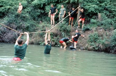 Marines of the 1ST Marine Brigade participate in a confidence-building exercise by crossing a river by rope. (Substandard image)