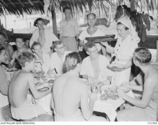 MADANG, NEW GUINEA. 1944-12-25. 500288 SISTER J. MESLEY, LEONGATHA, VIC, SERVES CHRISTMAS DINNER TO PATIENTS AT THE RAAF MEDICAL RECEIVING STATION