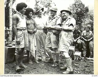 1942-10-08. TALKING WITH FRANCIS AND MICHAEL, TWO PAPUAN NATIVES, ARE MR A.B. CORBETT, DIRECTOR-GENERAL FOR CIVIL AVIATION, MR COLES M.H.R. AND MR DRAKEFORD, MINISTER FOR AIR. (NEGATIVE BY ..