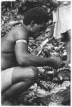 Larikeni of Furingudu measuring out kofu shell money to purchase packets of fish at market with sea people