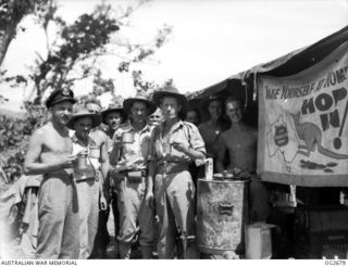 BUT AREA, DAGUA, NORTH EAST NEW GUINEA. C. 1945-05. THE RUMBLE OF AUSTRALIAN ARMY ARTILLERY COULD BE HEARD IN THE SCRUB BEHIND THE SALVATION ARMY'S RED SHIELD FRONT LINE COFFEE BAR WHERE THE RAAF ..