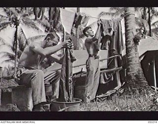 MILNE BAY, NEW GUINEA. 1943-06-26. QP8576 DRIVER G. BERE AND QX52592 DRIVER W. L. LAVERACK-ROBINSON ON WASHING DAY AT THE TRANSPORT LINE OF THE 5TH AUSTRALIAN DIVISION