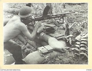 BOUGAINVILLE ISLAND, 1945-01-16. QX40671 PRIVATE J. BIGGERS, 47TH INFANTRY BATTALION GIVING COVERING FIRE WITH HIS BREN GUN TO A PATROL MOVING OUT FROM "A" COMPANY POSITIONS IN THE HUPAI-SAPANI ..