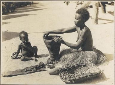 Mailu Island types [woman and child seated on the sand with the woman handbuilding a clay pot] Frank Hurley