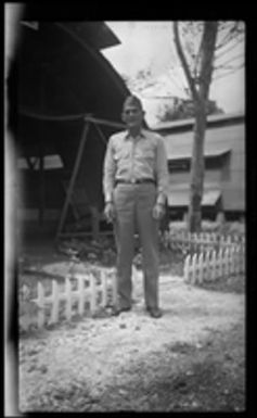 [Serviceman outside Quonset hut]