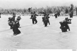 Ramu Valley, New Guinea. 1943-10-05. Members of A Company, 2/27th Australian Infantry Battalion, AIF, crossing the Surinam River