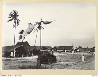 BORAM BEACH, WEWAK AREA, NEW GUINEA. 1945-08-31. THE ENTRANCE TO THE CAMP LINES OF THE 2/15 FIELD AMBULANCE SHOWING TRANSPORT PARK IN THE FOREGROUND