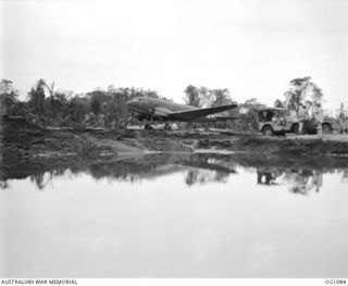 AITAPE, NORTH EAST NEW GUINEA. C. 1944-06. A US DOUGLAS TRANSPORT AIRCRAFT ON TADJI STRIP. THE CRATER IN THE FOREGROUND WAS MADE BY THE HEAVY ALLIED BOMBING WHICH PRECEDED THE INVASION ON ..