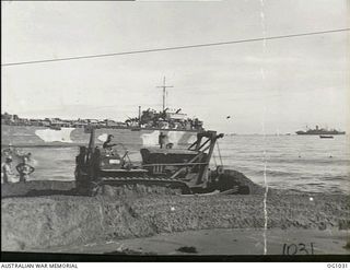 AITAPE, NORTH EAST NEW GUINEA. 1944-04-22. RAAF BULLDOZER CHURNS UP SAND AS IT CLEARS A PATH FOR TRUCKS AS THEY COME OFF A LANDING SHIP, TANK (LST)