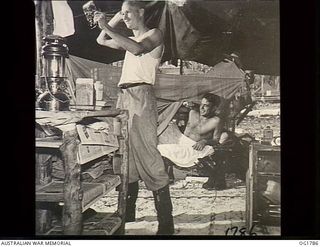 MOMOTE, LOS NEGROS ISLAND, ADMIRALTY ISLANDS. C. 1944-04. FIGHTER PILOTS PUT IN LONG DAYS. EVERY OTHER DAY FINDS THEM ON STAND-BY. HERE, TWO PILOTS OF NO. 76 (KITTYHAWK) SQUADRON RAAF PREPARE TO ..