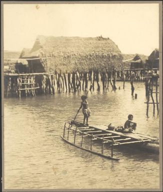 Two children on an outrigger canoe, one poling, Hanuabada, Papua, ca. 1923 / Sarah Chinnery