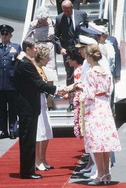 President Ronald Reagan shakes hands with Admiral William J. Crowe Jr., Commander in CHIEF, Pacific, as he is greeted by Admiral and Mrs. Crowe upon his arrival. Mrs. Nancy Reagan is greeted by Mrs. George Ariyoshi, wife of the Governor of Hawaii. The Reagans are making a two day rest stop prior to continuing on to Mainland China