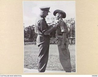 TOROKINA, BOUGAINVILLE. 1945-09-24. MAJOR GENERAL W. BRIDGEFORD, GENERAL OFFICER COMMANDING 3 DIVISION, PRESENTING LIEUTENANT R.S. JACKSON WITH THE MILITARY CROSS DURING PRESENTATION OF AWARDS AND ..