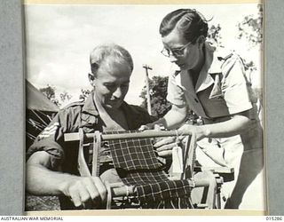 1943-07-26. NEW GUINEA. MRS VERA MORTON WITH SGT. STOKES OF AUBURN, VIC., WORKING A HAND LOOM ON WHICH HE IS MAKING A SCARF. MRS MORTON WAS THE LAST WOMAN TO BE EVACUATED FROM NEW GUINEA, AND IS ..