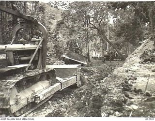 KILIGIA, NEW GUINEA. 1944-04-04. ANGLE DOZERS USED BY THE ROYAL AUSTRALIAN ENGINEERS TO CUT APPROACHES TO A NEW BRIDGE WHICH WILL SPAN THE SOWI RIVER REPLACING USE OF THE FORD AT KILIGIA