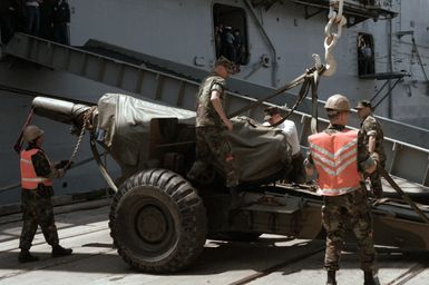 Marines load a Howitzer aboard the amphibious assault ship USS GUAM (LPH 9) during Exercise SOLID SHIELD '87