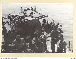 BUT AREA, NEW GUINEA. 1945-02-26. OBSERVATION OFFICES OF THE 4TH TACTICAL RECONNAISSANCE UNIT, 6TH DIVISION, AND MEMBERS OF THE RAN GUN CREWS WATCH THE COASTLINE AS HMAS SWAN PROCEEDS TO THE TARGET ..