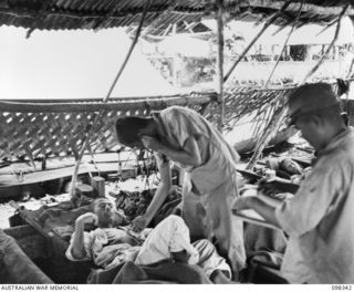 MUSCHU ISLAND, NEW GUINEA. 1945-10-27. JAPANESE DOCTOR EXAMINING A PATIENT SUFFERING FROM MALARIA. CASUALTIES AT THE HOSPITAL ON THE ISLAND HAVE BEEN HIGH - MORE THAN 180 HAVE DIED FROM VARIOUS ..