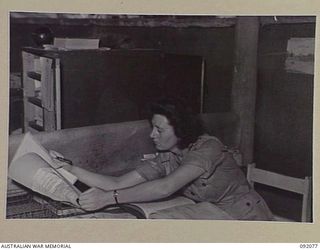 LAE, NEW GUINEA. 1945-05-20. CORPORAL T.L. NORTHFIELD, FILING CLERK, CHECKING BULK CANTEENS RECORDS AT HEADQUARTERS AUSTRALIAN ARMY CANTEEN SERVICE