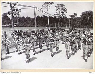 TOROKINA, BOUGAINVILLE. 1945-09-24. MEMBERS OF THE COMPOSITE BAND, 15 INFANTRY BRIGADE, PASSING THE SALUTING BASE DURING THE MARCH PAST AT A PARADE HELD AT GLOUCESTER PARK. THE SALUTE WAS TAKEN BY ..