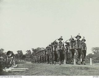 LAE, NEW GUINEA. 1944-03-08. MEMBERS OF THE 47TH INFANTRY BATTALION, 29TH INFANTRY BRIGADE, PASSING THE SALUTING BASE. VX20308 MAJOR-GENERAL F.H. BERRYMAN, CBE, DSO, GENERAL OFFICER COMMANDING 2ND ..